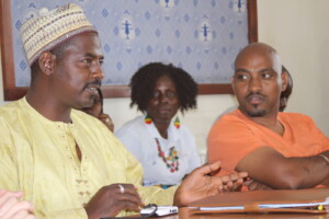 Duni Jedoh giving explanation at the Tanzanian Women Lawyers Association while James Jarso and Kou Dorkago listen.